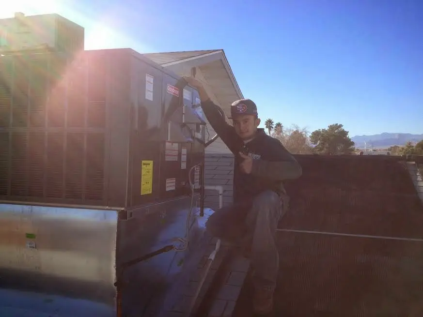 HVAC technician performing AC Tune-Up on a rooftop unit in Morro Bay